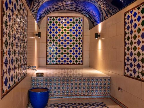 a bathroom with a large mosaic window and a tub at Finest Retreats - Berry Pen Cottage in Kingham