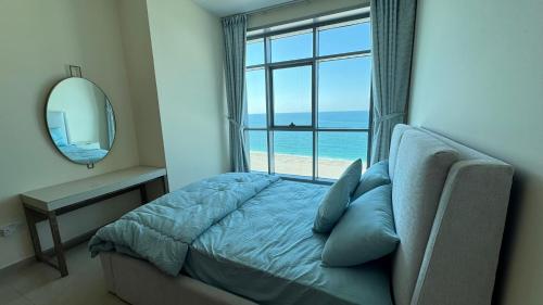 a bedroom with a bed with a view of the ocean at SeaView Beachfront with pool,sauna,jacuzzi,gym,cafe in Ajman 