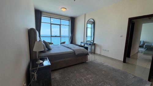 a bedroom with a bed with a view of the ocean at SeaView Beachfront with pool,sauna,jacuzzi,gym,cafe in Ajman 