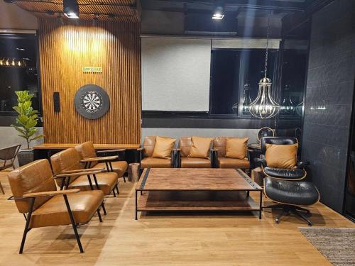 a lobby with a table and chairs and a clock at Black Sheep House Khaoyai by ALPHATEL PARTNER in Pong Talong