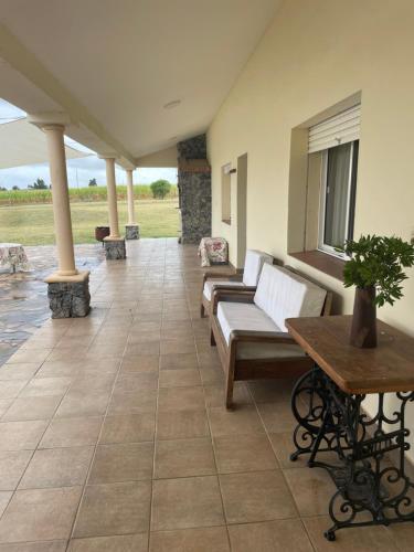 a porch with couches and a table on a patio at CHACRA Los Ombues in Colonia Valdense