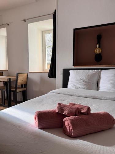 a bed with a pink towel on it at Le studio in Pontrieux