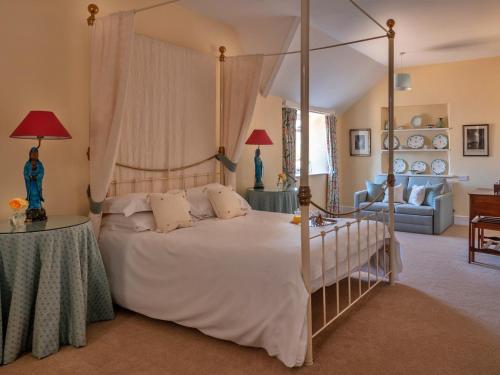a bedroom with a canopy bed and a living room at Finest Retreats - Lodge Cottage in Kingham