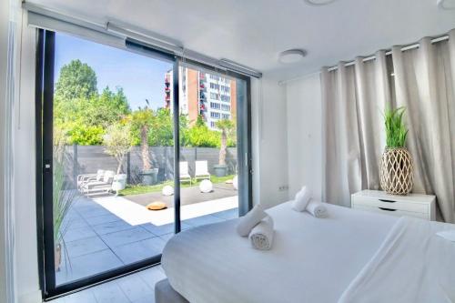 une chambre blanche avec une grande fenêtre et un lit dans l'établissement Maison Design proche gares et centre ville de Lille, à Mons-en-Baroeul