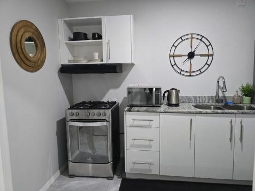 a white kitchen with a stove and a sink at Walk to the BEACH Cozy Condo in Marisule with pool in Gros Islet