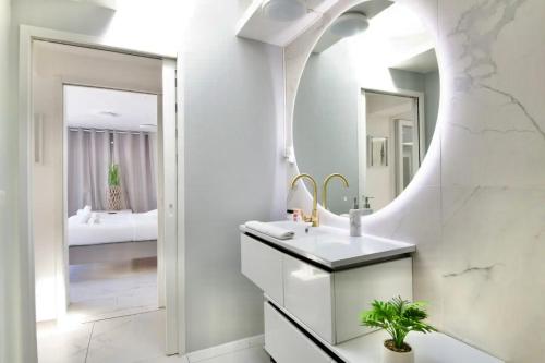 une salle de bain avec un lavabo et un miroir dans l'établissement Maison Design proche gares et centre ville de Lille, à Mons-en-Baroeul