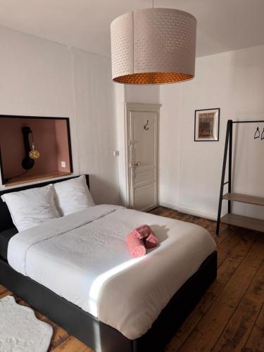 a bedroom with a bed with two pink towels on it at Le studio in Pontrieux