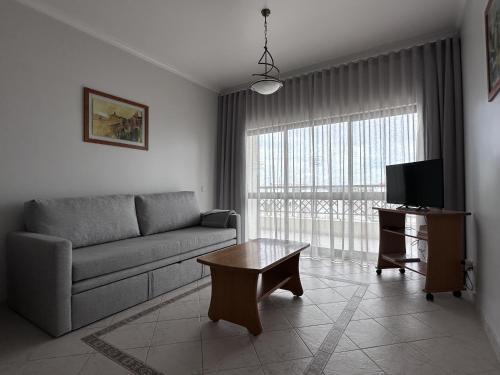 a living room with a couch and a tv at BayView Albufeira in Albufeira