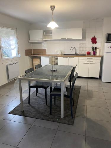 une cuisine avec une table et des chaises dans une cuisine dans l'établissement Le Mathiez, à Dijon