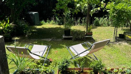 two chairs sitting in the grass in a garden at Curt da Beta - Casa vacanze con giardino, in Corte del XVIII secolo in Malnate