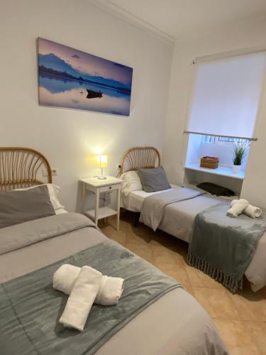 a bedroom with two beds and a window at Vivienda 2 dormitorios Churriana-Aeropuerto in Málaga