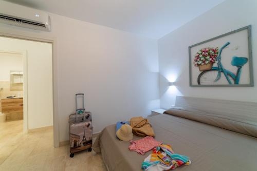 a bedroom with a bed with a suitcase and a painting at Villa Federica by Etra Vacanze in Orosei