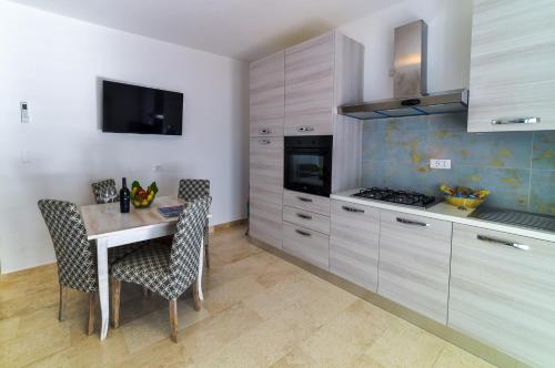 a kitchen with a table and chairs and a stove at Villa Federica by Etra Vacanze in Orosei