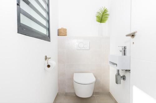 a white bathroom with a toilet and a sink at The views from the home were beautiful in Cul de Sac