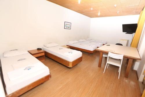 a room with four beds and a table and chairs at Hotel Belas Artes in Rio de Janeiro