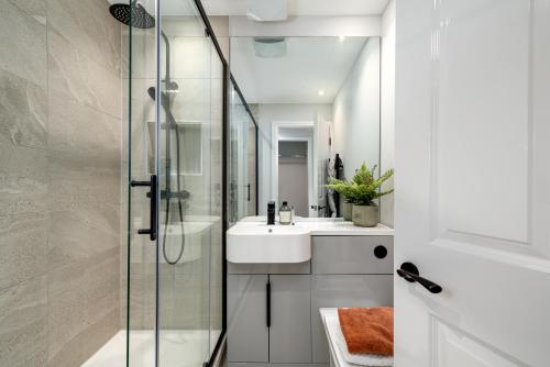 a bathroom with a glass shower and a sink at 62 Park Street - Urban Apartments in Bristol