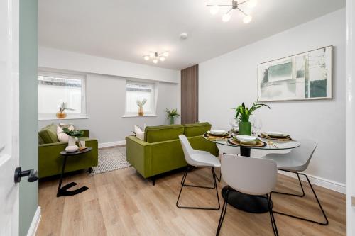 a living room with a green couch and a table at 62 Park Street - Urban Apartments in Bristol