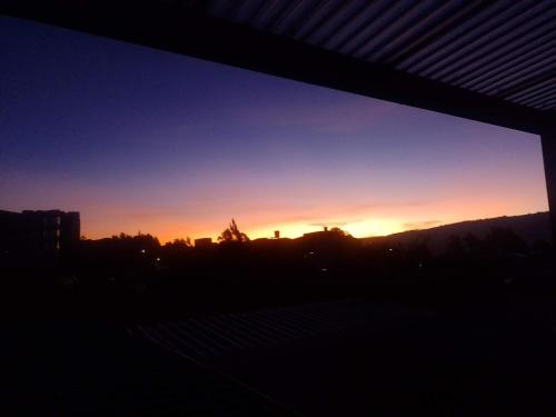 a sunset view from a window of a city at Apartamentos CasaMJ Tunja Confort y Parqueadero in Tunja