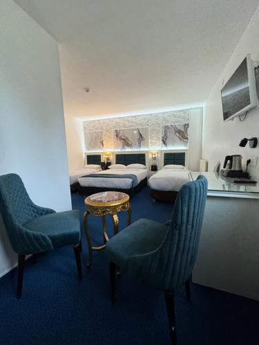 une chambre d'hôtel avec deux lits, une table et des chaises dans l'établissement Hotel Grand Paris, à Villejuif