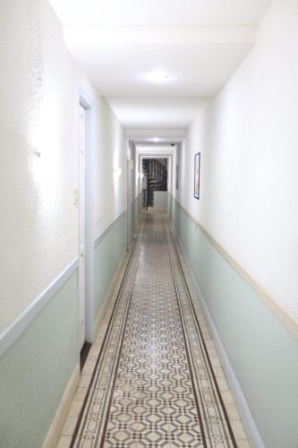 an empty corridor with a tile floor in a hallway at Hotel Belas Artes in Rio de Janeiro