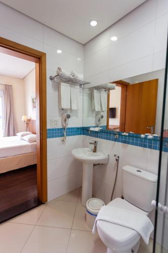 a bathroom with a toilet and a sink at Hotel Amália in Sao Paulo