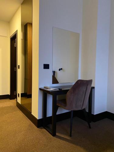 a desk in an office with a chair and a mirror at Hotel Sun Loznica in Loznica