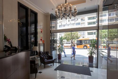a person walking in a building lobby with a chandelier at Hotel Amália in Sao Paulo