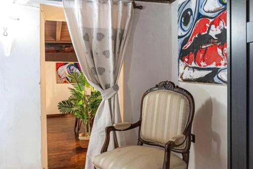 a chair sitting in a room with a curtain at Artist's Suites in Spoleto