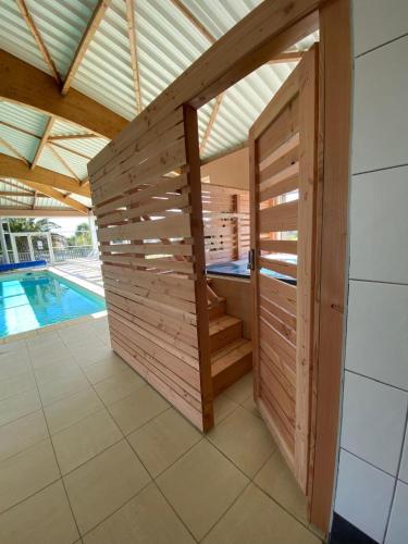 a sauna in a wooden wall next to a swimming pool at Résidence de Nodeven in Guissény