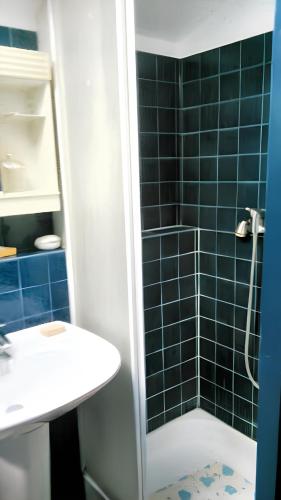une salle de bain avec un lavabo et une douche avec du carrelage bleu dans l'établissement Maison de charme à Saint-Père avec cheminée cosy, à Saint-Père