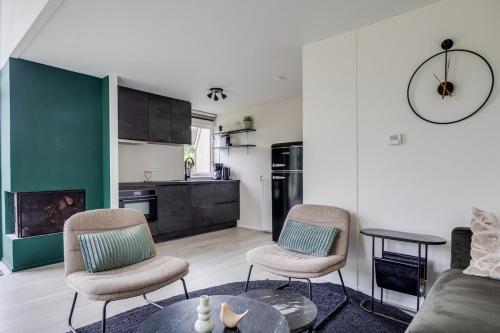 a living room with two chairs and a table at Bladkoning I Trendy Huisje met Openhaard in Zwiggelte