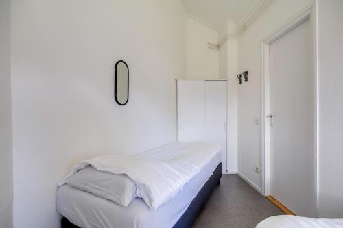 a bedroom with two beds and a mirror on the wall at Bladkoning I Trendy Huisje met Openhaard in Zwiggelte