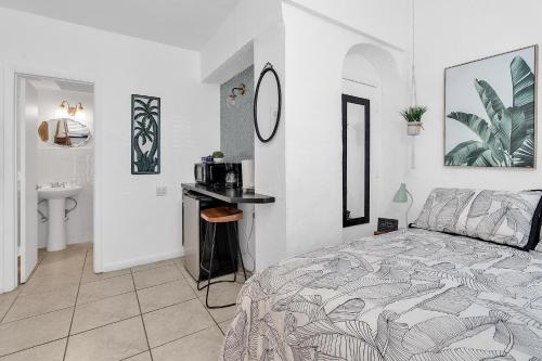 a white bedroom with a bed and a sink at Private Studio in Little Havana in Miami