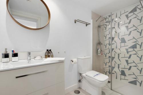 a white bathroom with a toilet and a mirror at Beautiful Family Apartment by Costarentals- Ref 24 in Sitio de Calahonda