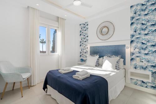 a bedroom with a blue and white bed and a chair at Beautiful Family Apartment by Costarentals- Ref 24 in Sitio de Calahonda