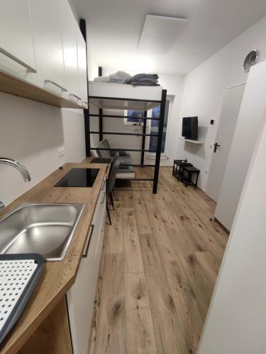 a kitchen with a sink and a wooden floor at apartma Pohorc - Praprot in Pohorje