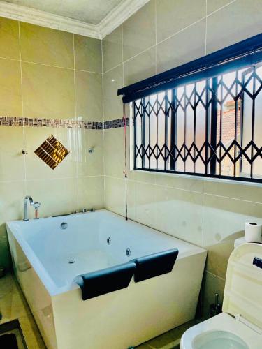 a bathroom with a bath tub and a toilet at Cloud 9 Elevate your Stay in Nelspruit