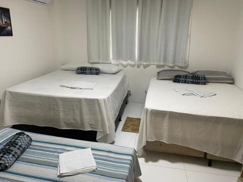 a room with two beds and a window at Brisa Bitingui in Japaratinga