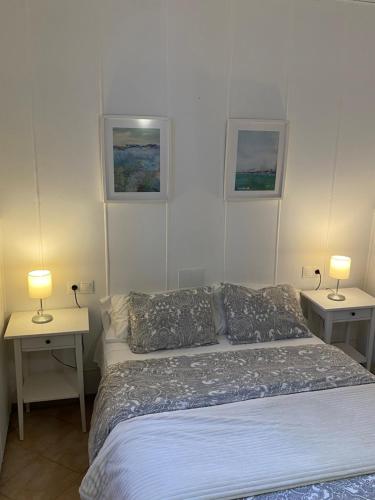 a bedroom with a bed and two tables with lamps at Vivienda 2 dormitorios Churriana-Aeropuerto in Málaga