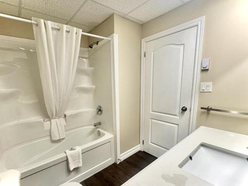 a bathroom with a tub and a shower and a sink at Big Tub Resort & Marina in Tobermory