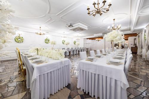 a row of tables in a banquet hall with white linens at Dworek Kurowski in Szczecin