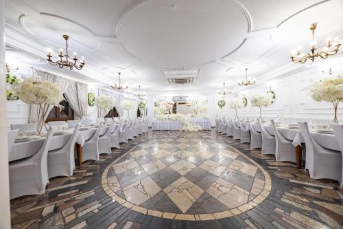 a room with rows of tables and white chairs at Dworek Kurowski in Szczecin