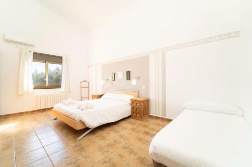 a white bedroom with two beds and a window at Villa Sunset Boulevard Lujo in Puntiró