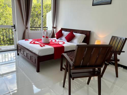 a bedroom with a bed with a table and chairs at Kandy Alpine Breeze in Kandy