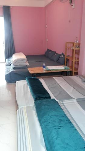 a living room with two beds and a table at HangNga homestay - hotel in Phủ Từ Sơn