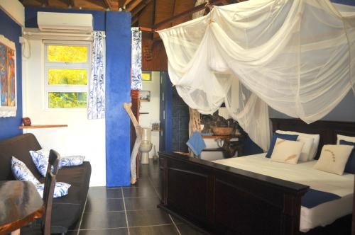 a bedroom with a bed with a mosquito net at Mango Island Lodges in Saint Joseph