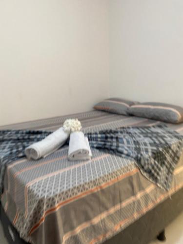 a bed with two towels on top of it at Brisa Bitingui in Japaratinga