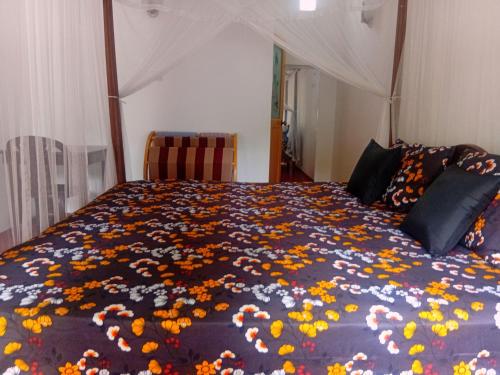 a bedroom with a bed with flowers on it at Bakery Family Guest House in Mirissa
