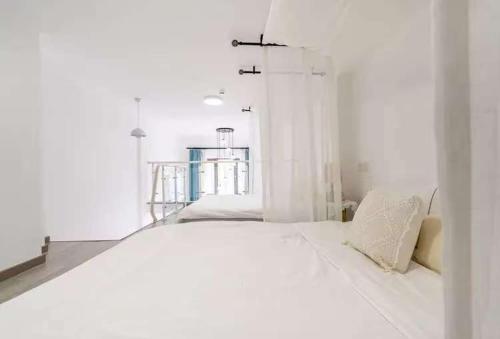 a white room with a bed and a staircase at 翠畔loft公寓 in Guangzhou
