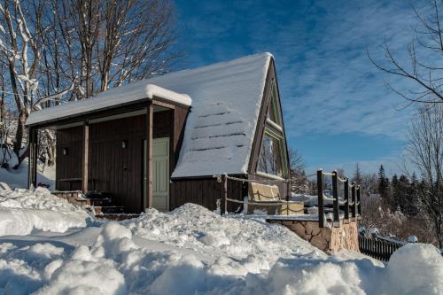 eine schneebedeckte Hütte mit Schnee drumherum in der Unterkunft Alemiło mini - domek z balią i widokiem na Babią Górę in Zawoja